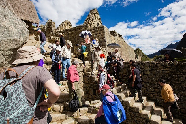 Touristen besichtigen die Ruinenstadt im Sonnenschein.