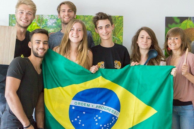 Das viventura Marketing Team hält die brasilianische Flagge hoch.