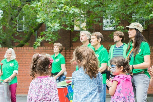 Kinder tanzen während die Berliner Sambagruppe Green Igelz trommelt beim viventura Sozialtag in Berlin.