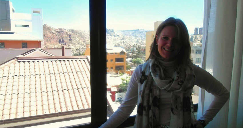 #viventurameets: Sozialprojekte in Bolivien - Hester steht im viventura Büro in La Paz am Fenster, im Hintergrund die Berge.